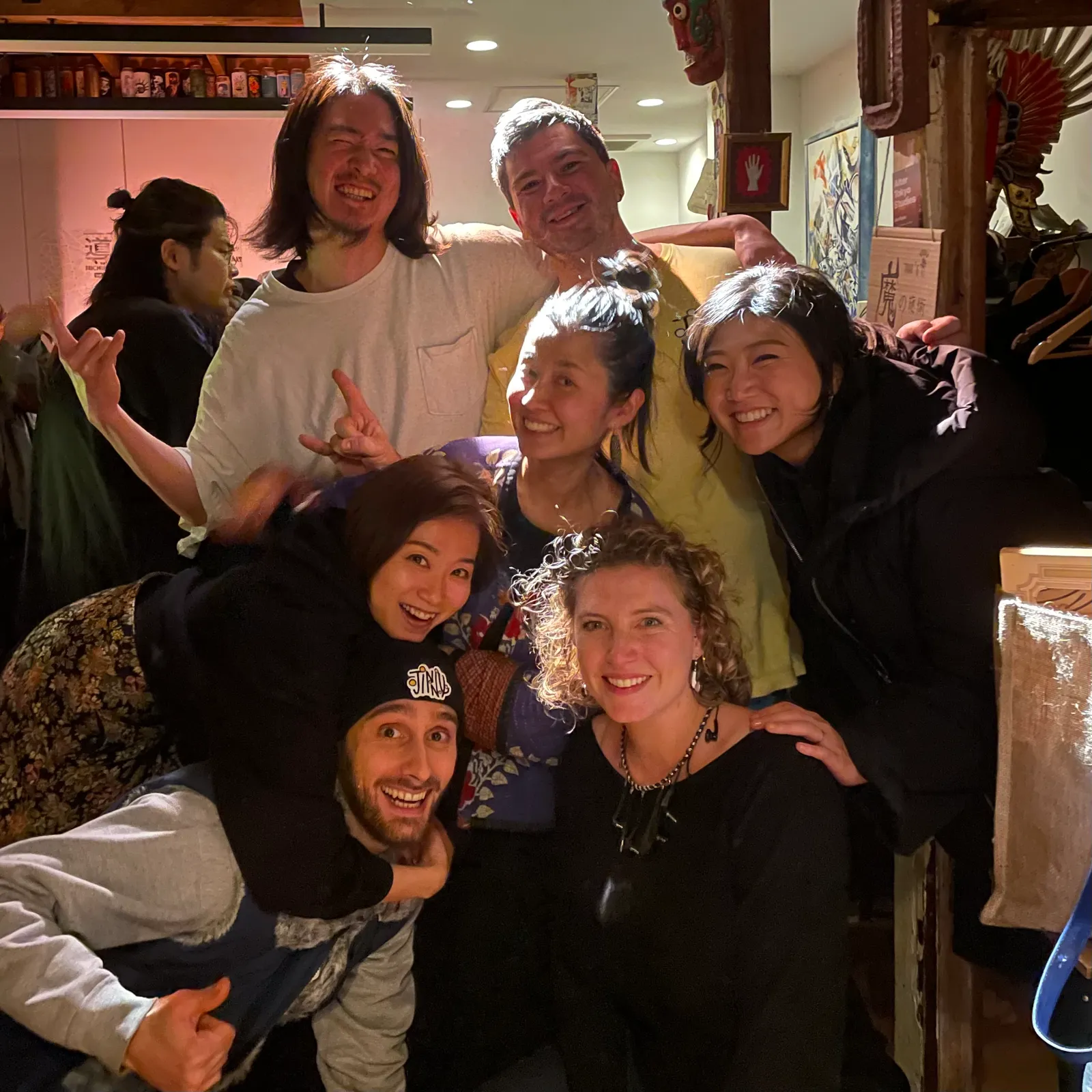 Smiling friends and supporters squeeze together for a group photo in a warmly lit room